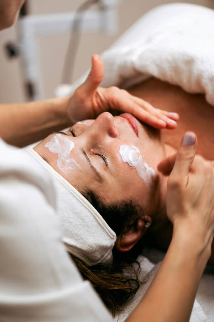 Soin du visage réalisé par une esthéticienne diplômée dans un institut de beauté à Toulouse – application de crème hydratante sur une cliente détendue chez DOUCE'HEURE
