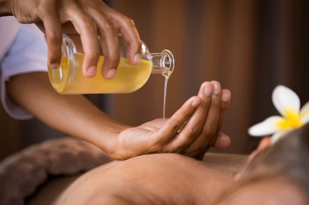 Application d'huile de massage végétale lors d’un soin du corps dans un institut de beauté à Toulouse – modelage relaxant chez DOUCE'HEURE